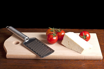 Cheese, grater and red tomato