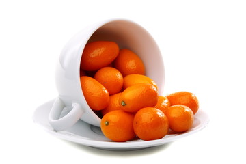 Kumquats in a white cup.