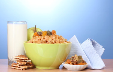 tasty cornflakes in green bowl, apples and glass of milk