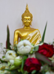 Altar flowers with golden statues.