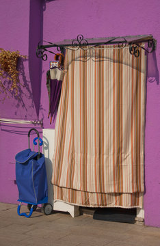 Colorful violet house on the island of Burano: bag, curtain, umb