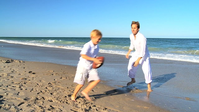 Young Father and Son Playing Ball on a Beach