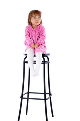 The little girl sits on a high chair. Isolated on a white backgr