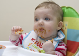 Nine month old baby learning to feed herself.