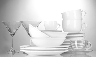 empty bowls, plates, cups and glasses on grey background