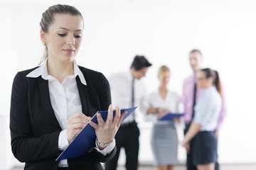 business woman standing with her staff in background