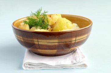 potatoes garnished with dill in a brown earthenware dish
