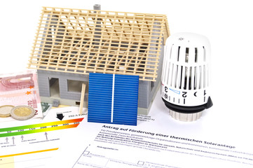 Haus im Bau mit Solarzelle, Energieausweis und Thermostat