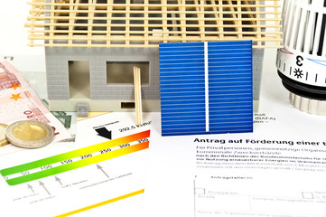 Haus im Bau mit Solarzelle, Energieausweis und Thermostat