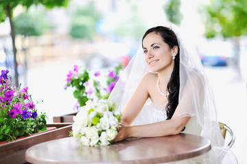 Happy young bride holding bridal bouquet