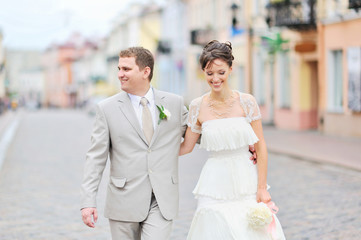 Happy bride and groom having fun in an old town