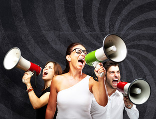 people shouting with megaphone against a grunge wall