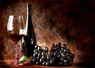 Vino rosso con grappolo di uva nera