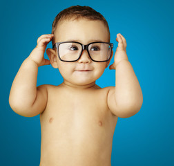 portrait of funny kid shirtless wearing glasses over blue backgr