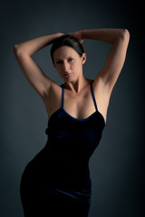 Fototapeta na wymiar Elegant woman in black dress against dark background.