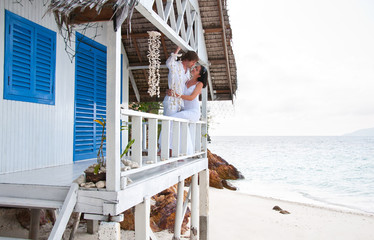 Romantic young couple in tropical beach house