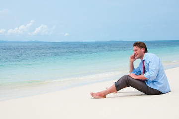 Fototapeta na wymiar Business man calling by cell phone on the beach