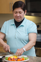 Fototapeta na wymiar Senior asian filipino woman preparing food
