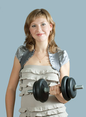 woman in dress exercising with barbell