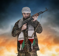 Naklejka premium Portrait of man standing with rifle while explosion in background