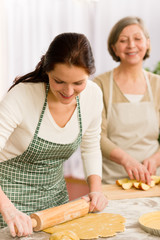 Obraz na płótnie Canvas Happy woman making dough for apple pie