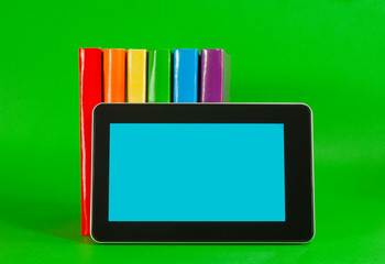 Row of colorful books and tablet PC