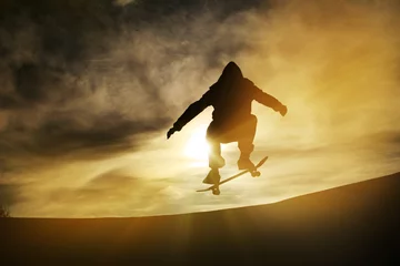 Fototapeten silhouette of skateboarder in sunset © Alex Koch