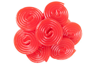 Pile of red licorice spirals on white background. Close up