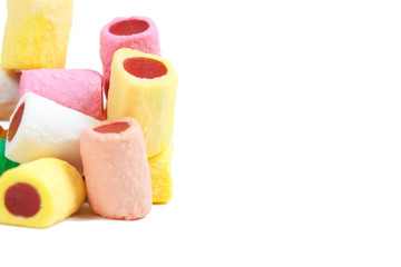 Pile of multicolored candy sticks on white background