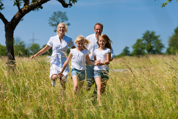 Glückliche Familie läuft in der Wiese