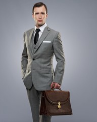Businessman with a briefcase isolated on grey.