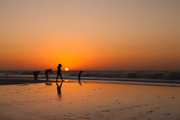 The silhouettes of people at the sunset background