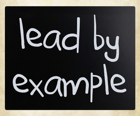 "Lead by example" handwritten with white chalk on a blackboard