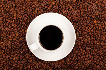 Cup of coffee on coffee beans