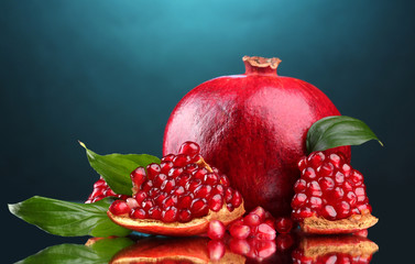 ripe pomegranate fruit with leaves on blue background