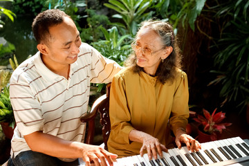 Fototapeta premium ethnic old mother and son happy playing piano together