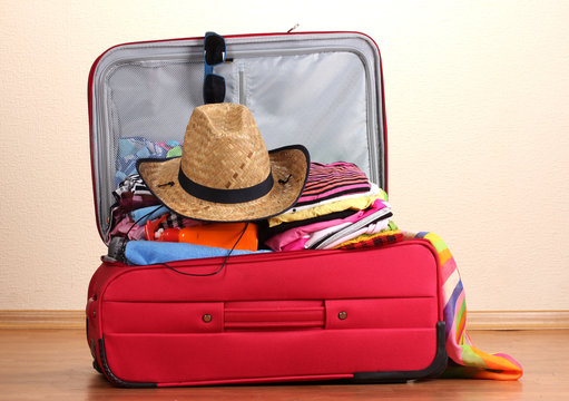 Open Red Suitcase With Clothing In The Room