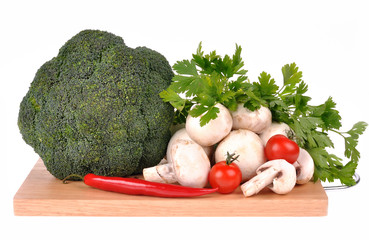 mushrooms brocolli pepper on the cutting board isolated on the w