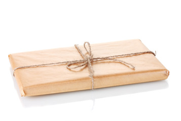 Parcel wrapped in brown paper tied with twine isolated on white