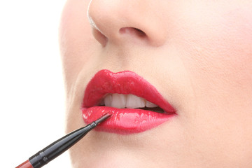 beautiful woman applying lip gloss