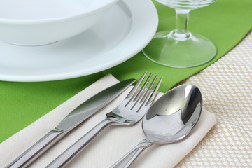 Table setting with fork, knife, spoon, plates, and napkin
