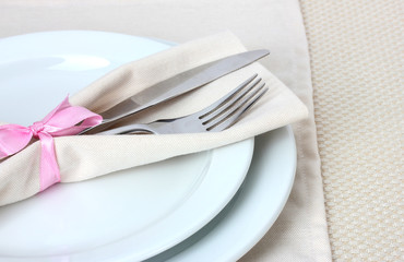 Table setting with fork, knife, plates, and napkin