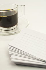 noteapd and black coffee on white background