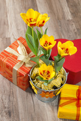 Fototapeta na wymiar It is red yellow tulips and gift boxes, a close up