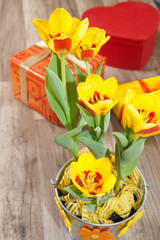 It is red yellow tulips and gift boxes, a close up
