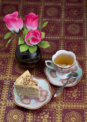 Breakfast in a retro style. Cake, tea with lemon and a bouquet