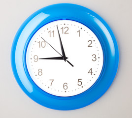 blue office clock on grey wall