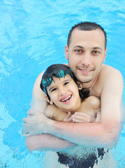 Father and son in pool, summertime