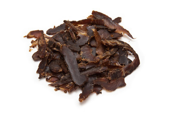 Sticed biltong (dried beef) on a white studio background.