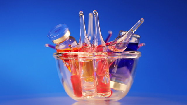 Healthcare medical concept: many vivid ampoule rotating on blue